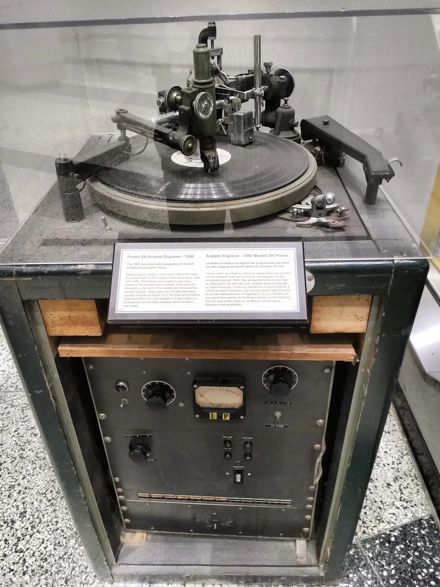 Vintage Presto disc-cutting machine with a platter, cutting head, control panel, and metal arm mounted in a cabinet.