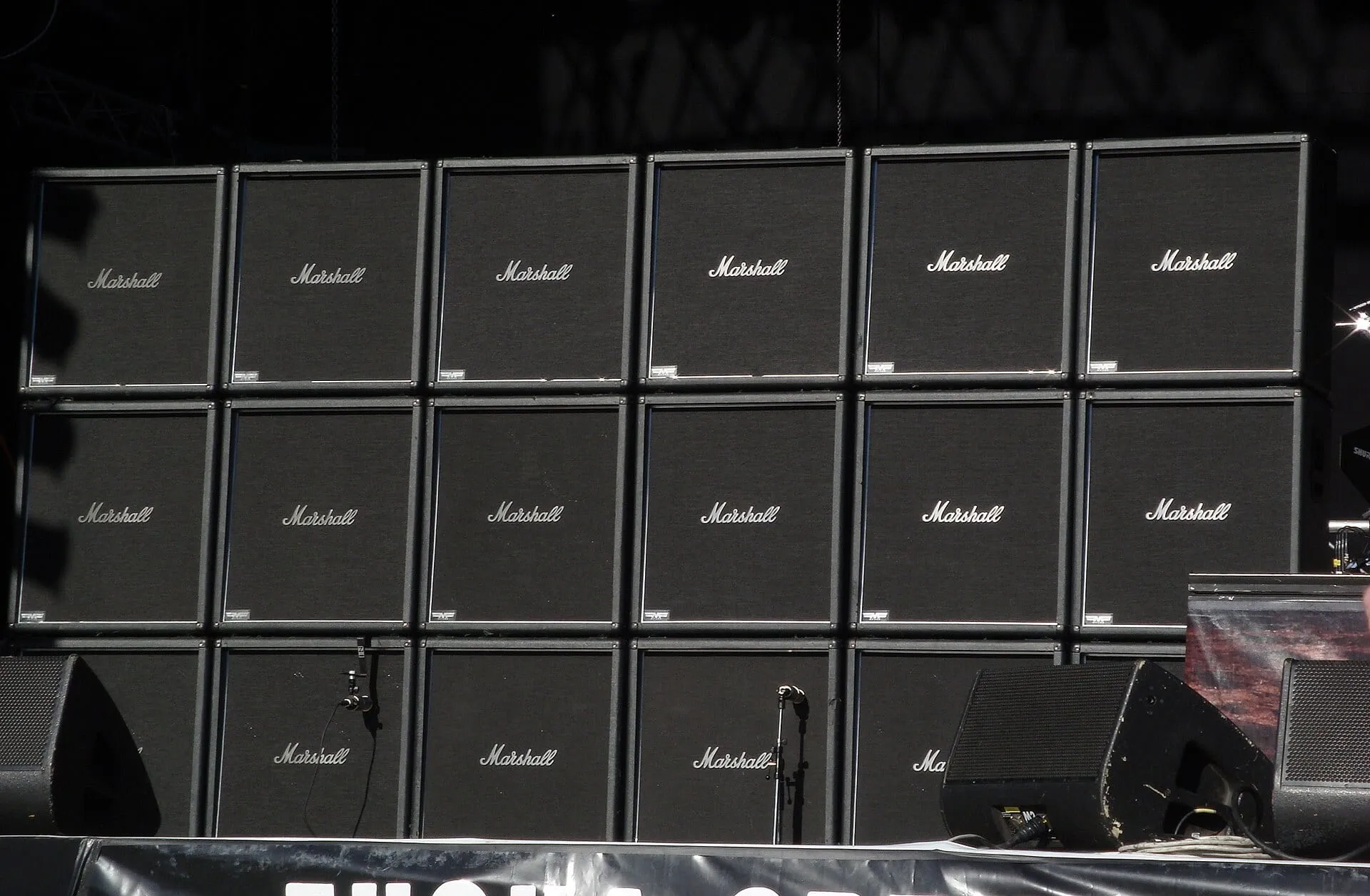 Eighteen black Marshall speaker cabinets form a wide wall across a festival stage before a Slayer performance in 2008.